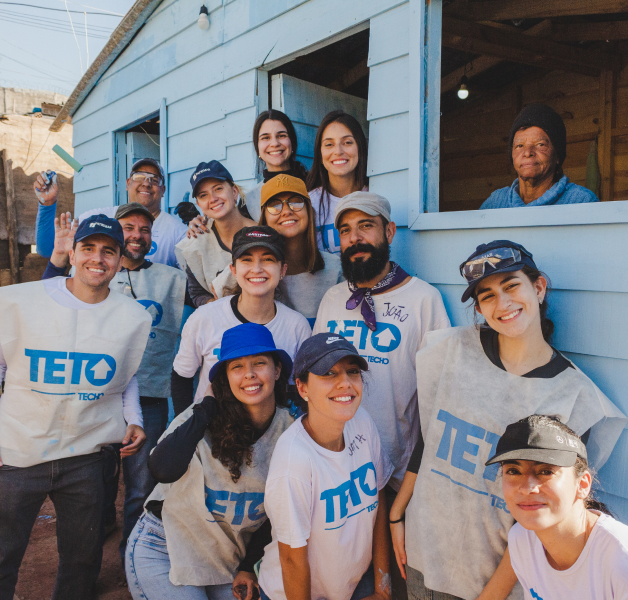 Equipe da Patrimar em trabalho voluntário para a ONG TETO durante a construção de uma moradia emergencial, promovendo impacto social positivo.